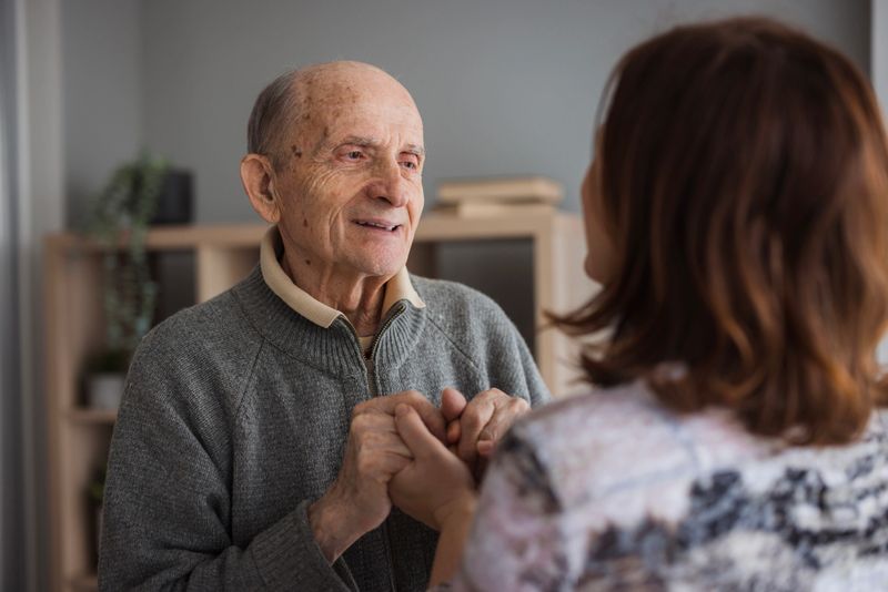 Loving father holding his daughter by hands and looking in her eyes