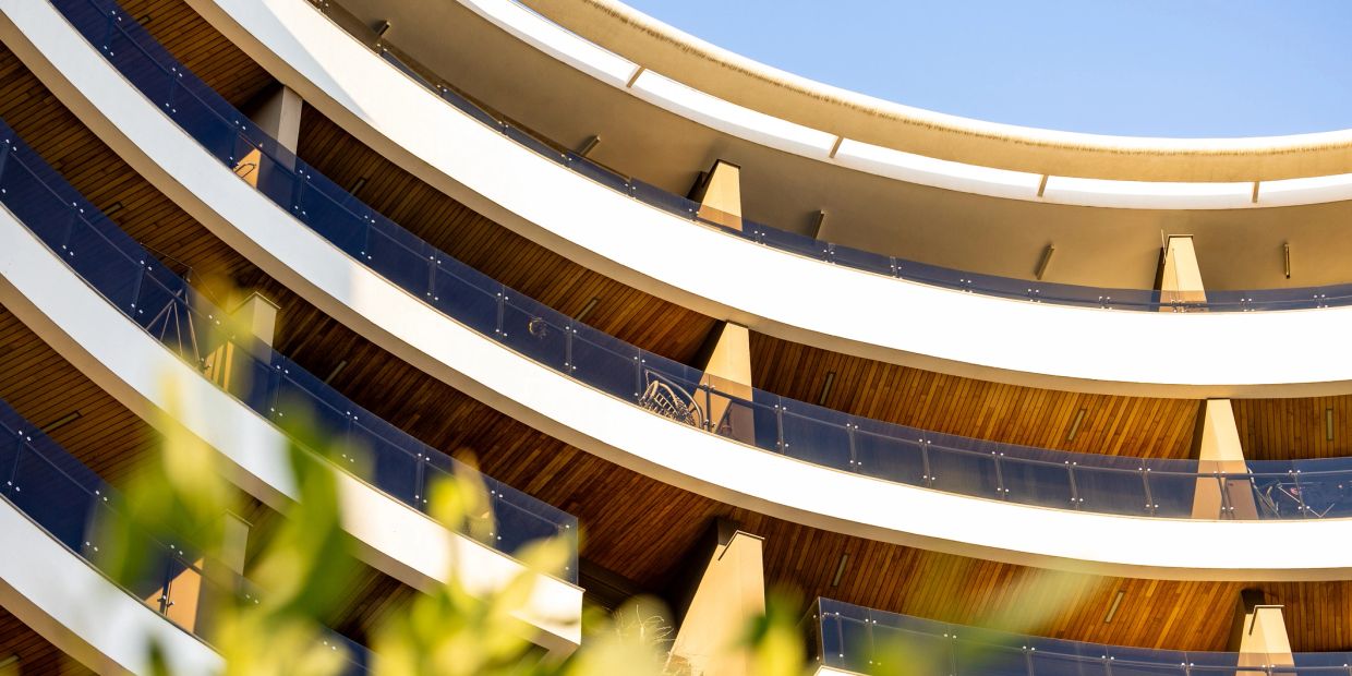 Curved balconies with glass railings on a modern building.