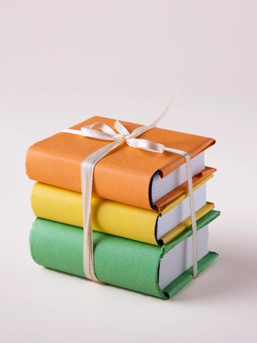 Three colorful books tied with a white ribbon.