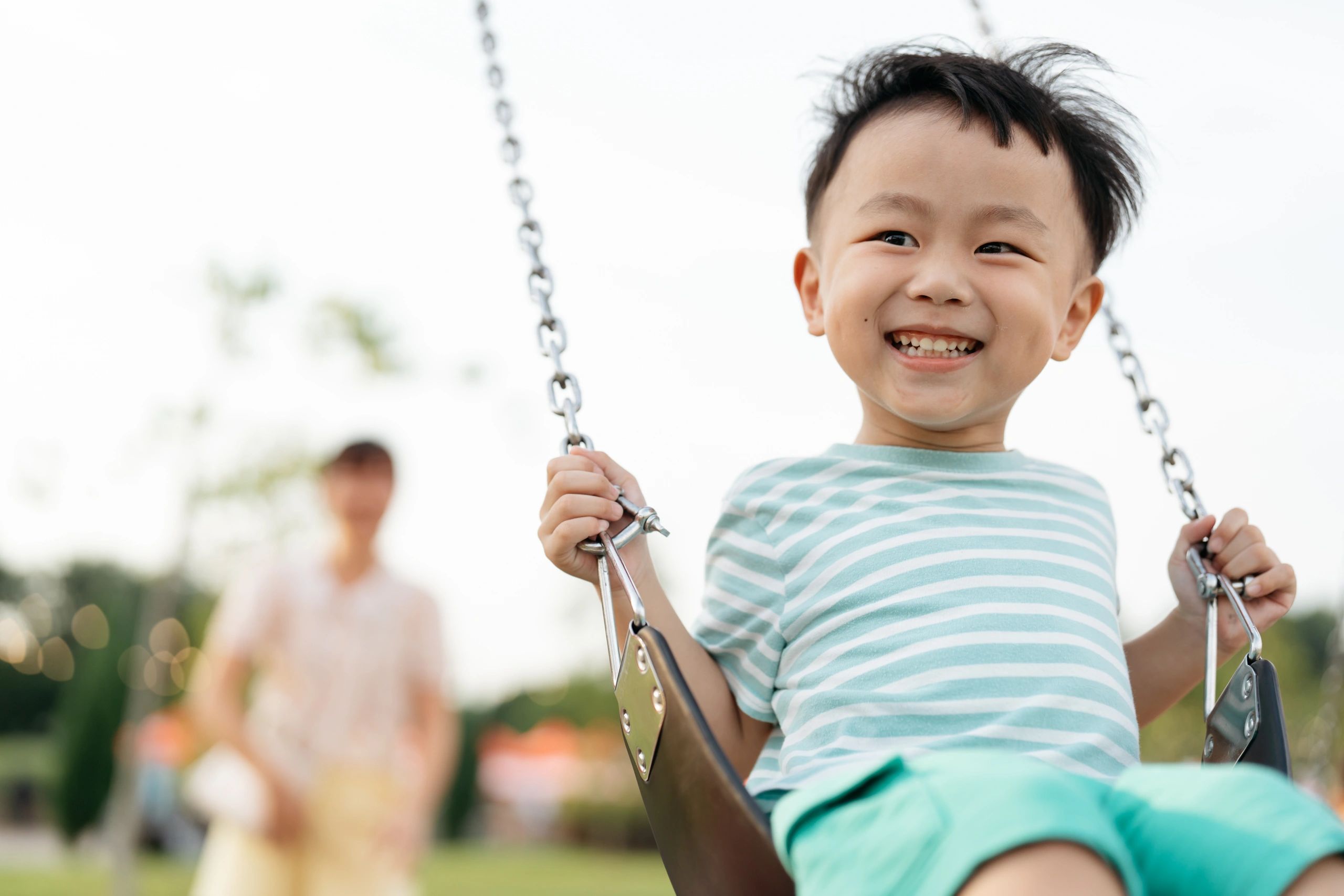 A happy child on a swing at the park.