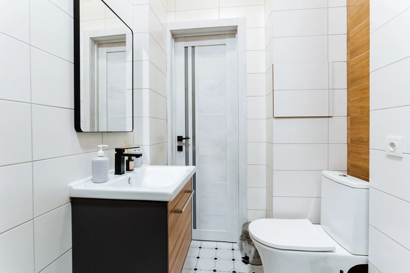 This bathroom has all essential elements for style and functionality a toilet, sink, and a strategically placed mirror, creating a comfortable space for personal hygiene and daily routines