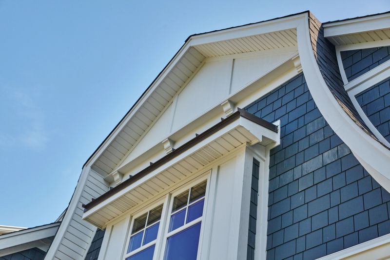 Close-up of modern residential architecture in Coldwater, Michigan, showcasing contrasting roof and wall textures under bright blue sky