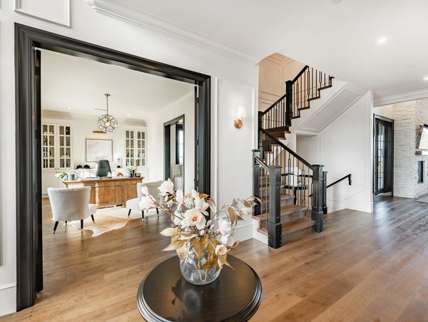 Bright home interior with wooden floors, staircase, and office space.