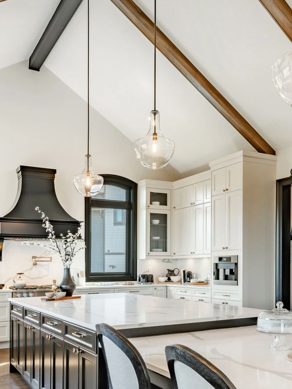 Modern kitchen with white cabinetry and black island.