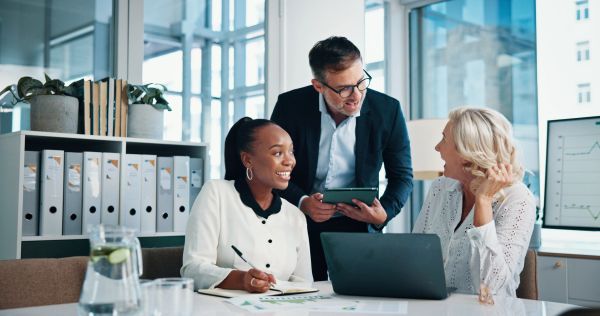 Three colleagues having a positive discussion in an office.