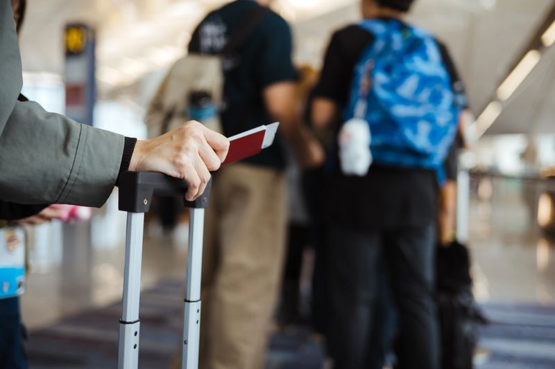 Ready For Travelling: An Unrecognizable Asian Holding Her Passport And Other Documents