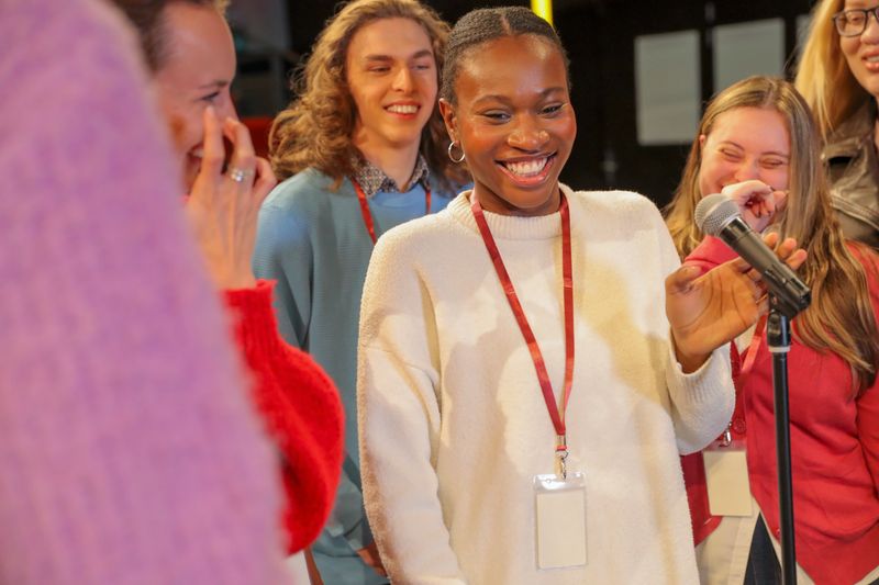 Group of people with disabilities standing in front of microphone on theater stage