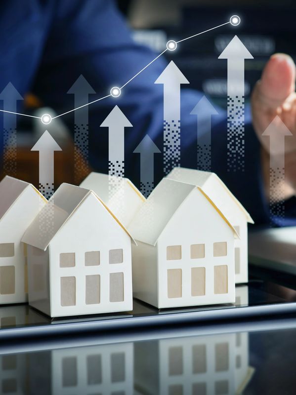 Miniature house models with digital arrows and graph showing real estate market growth.