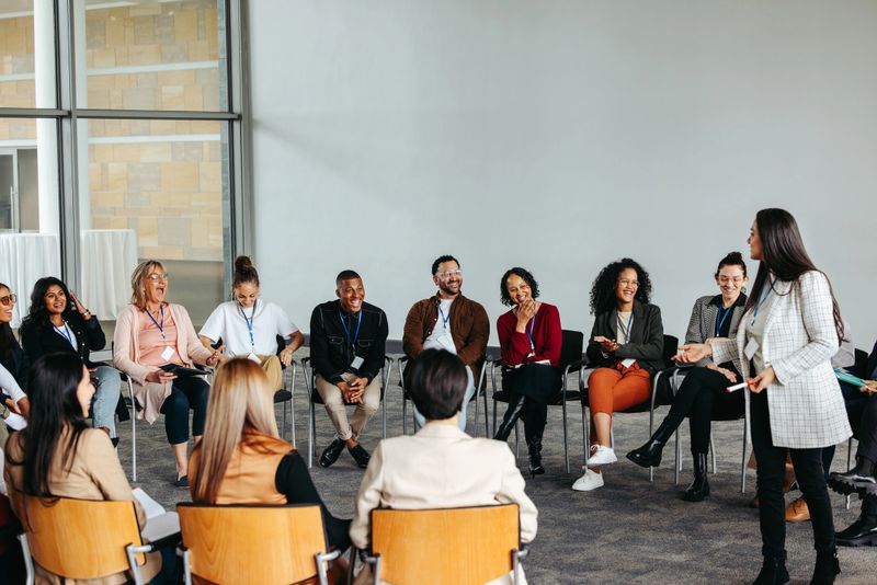 Motivational speaker interacting with a diverse and engaged audience during a conference, fostering an atmosphere of motivation and engagement.
