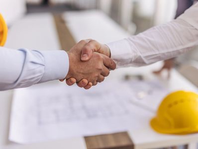 Two men shake hands in an architect’s office at the Ion in Midtown Houston.