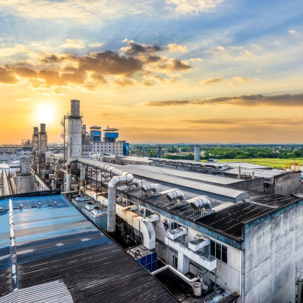 Industrial factory complex under a vibrant sunset sky.