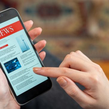 Une personne lit des nouvelles sur un smartphone.