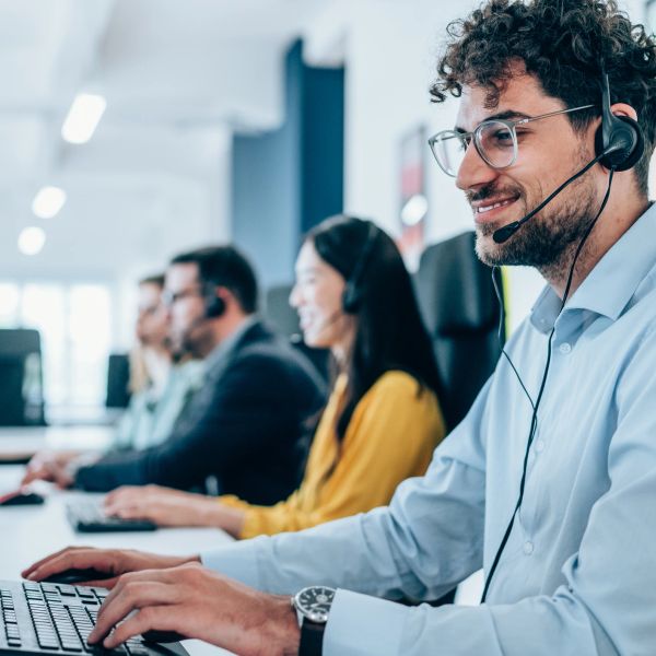 Customer service representatives working with headsets in a modern office.
