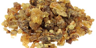 Close-up of dried frankincense resin pieces in various shades of brown and yellow.