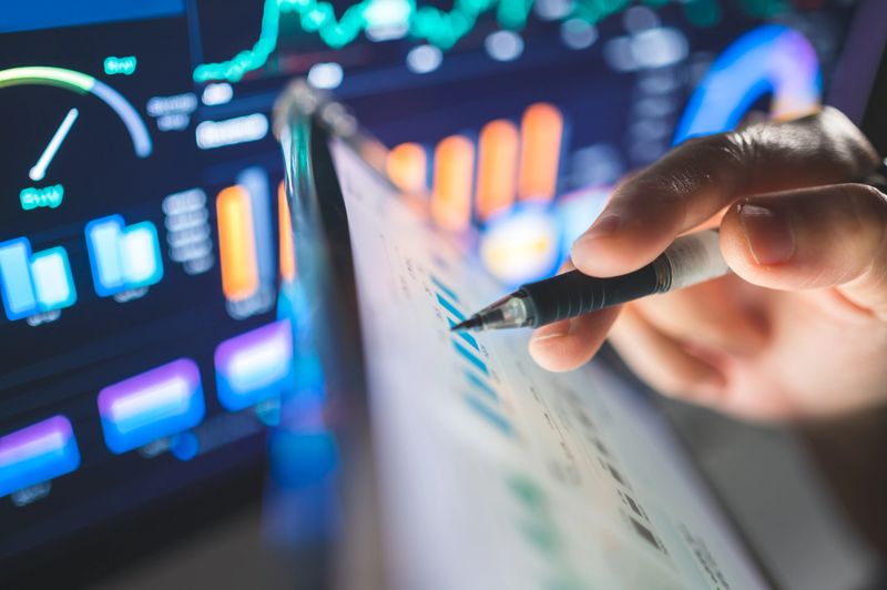 Millennial finance consulting investing financial data displayed on a touchscreen interface, emphasizing the speed and accuracy required for effective investment planning.