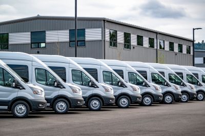 Row of white delivery vans parked.