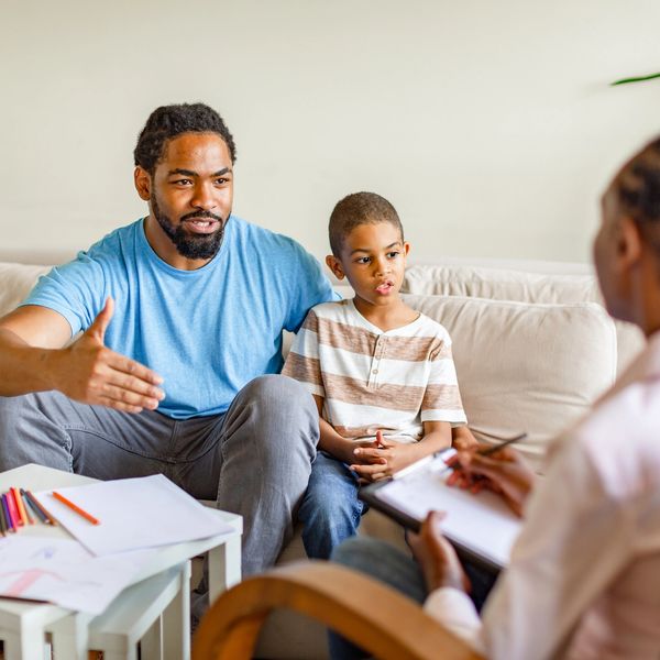 Father and son talking to a therapist during a counseling session.