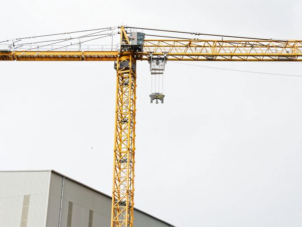 Yellow construction crane against a pale sky.