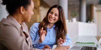 Two women smiling at each other
