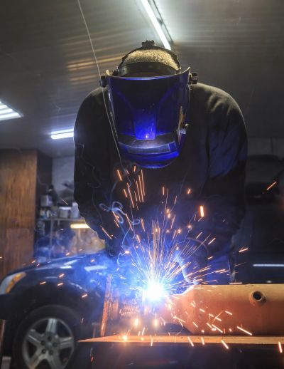 Person welding metal with sparks flying.