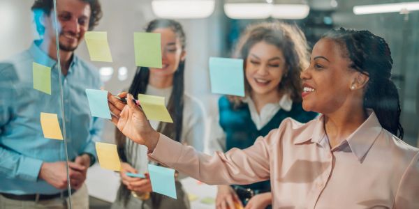 Group brainstorming with sticky notes in office.