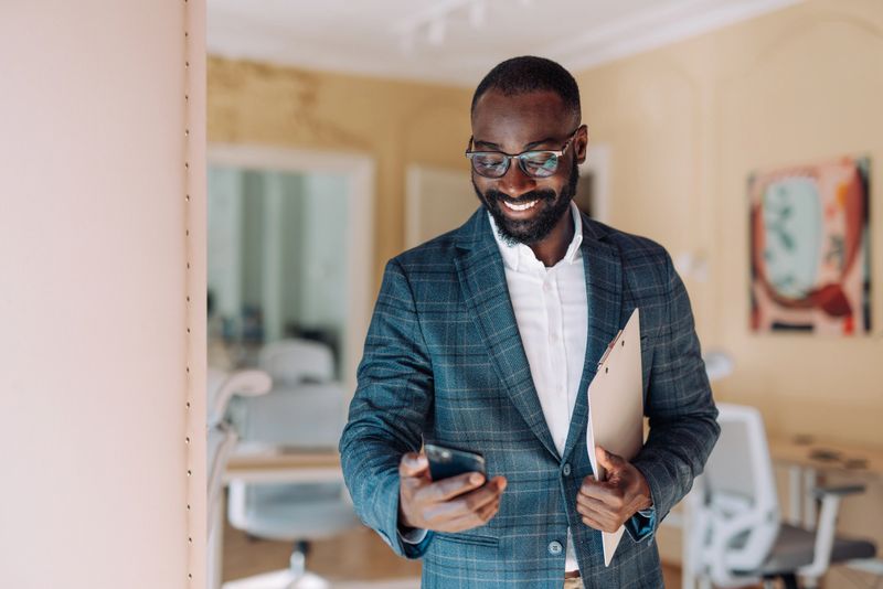 Shot of handsome young businessman using a smartphone in a modern office.