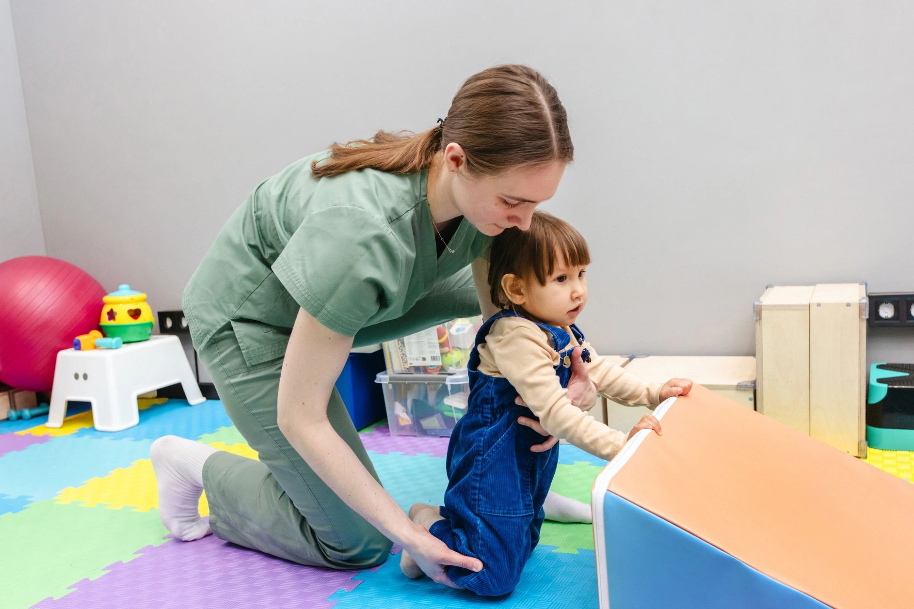 Allied Health Assistant with male child aged 3 using motor skills