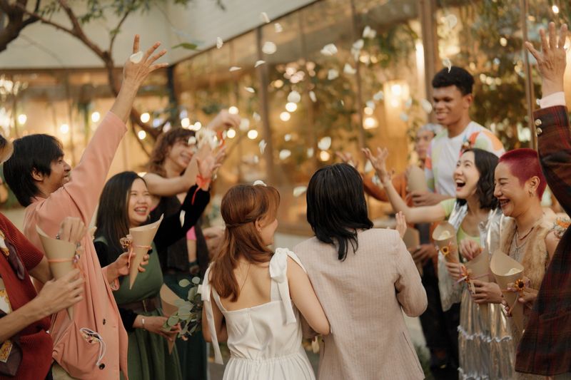 Asian bride and groom walk down the aisle with their arms in their arms. Guests cheered them on during the wedding ceremony.