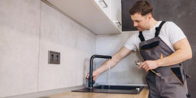 Man checking kitchen faucet.