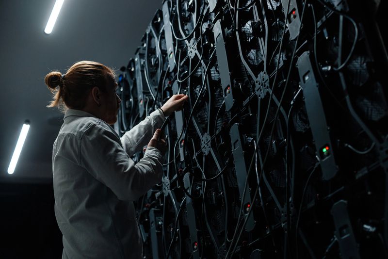 Technician working on a large LED screen, connecting and adjusting cables for optimal performance and troubleshooting any issues