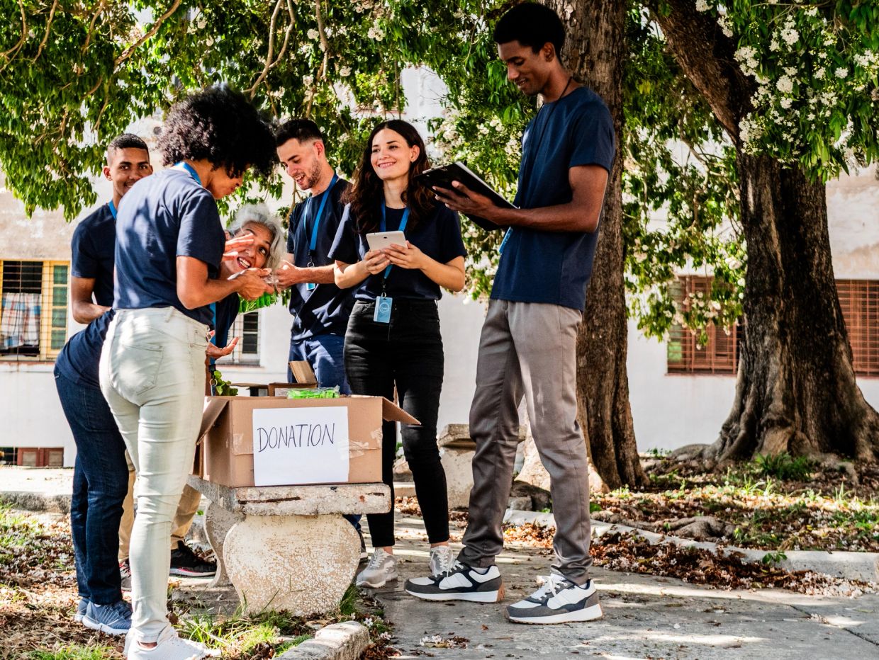 Volunteers organizing donations outdoors.