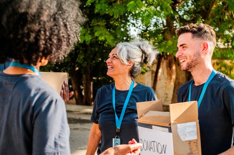 Volunteers talking and holding donation boxes outdoors