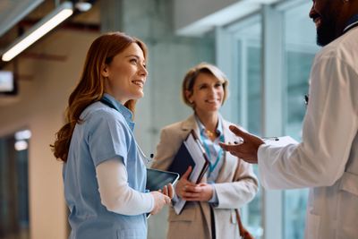 Healthcare professionals engaged in a positive discussion in a hospital.