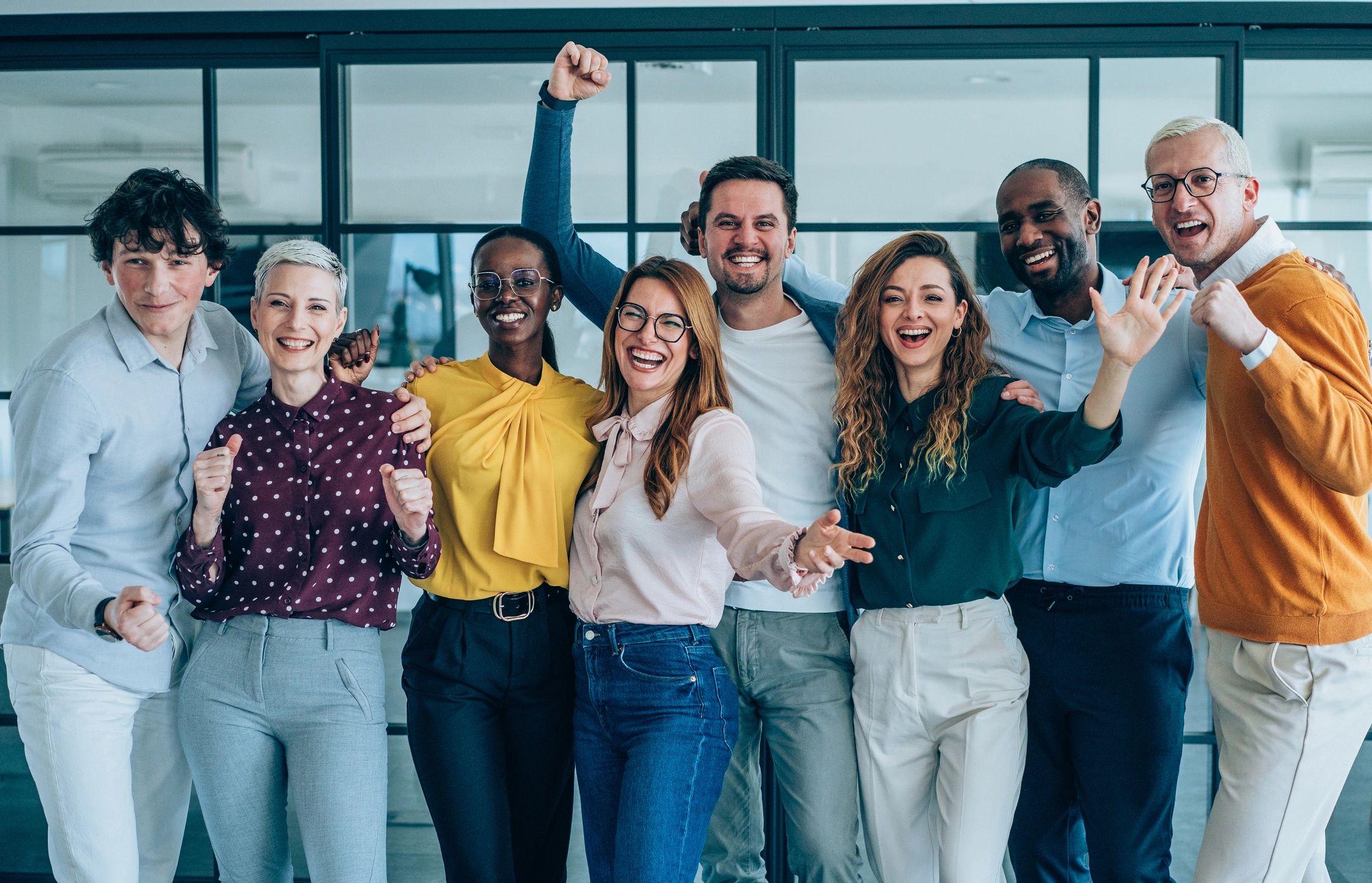 Group of diverse people celebrating happily indoors.