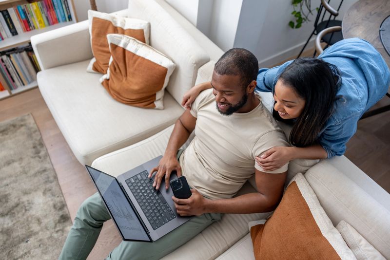 Happy African American couple using their laptop at home and smiling - lifestyle concepts
