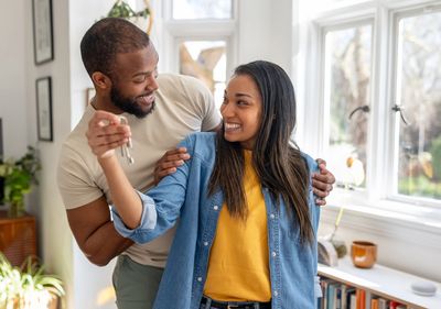 Happy couple holding keys, celebrating new home.