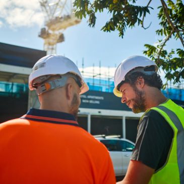 Two construction workers discussing at site.