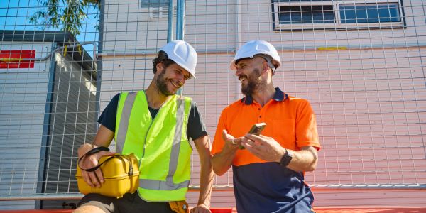 Two construction workers chatting and smiling.