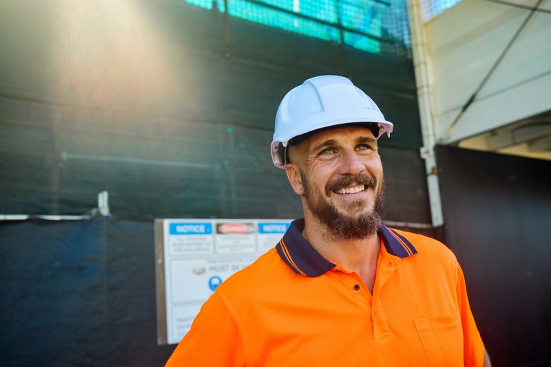 Portrait of a smiling engineer wearing an hardhat at a construction site in australia