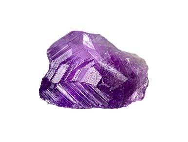 Close-up of a raw purple amethyst crystal on white background.