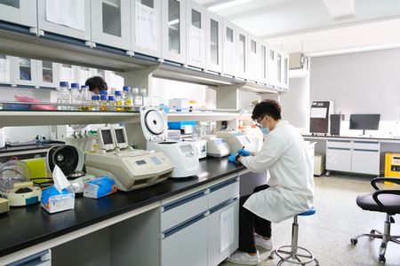 Scientist working with lab equipment in a modern laboratory.