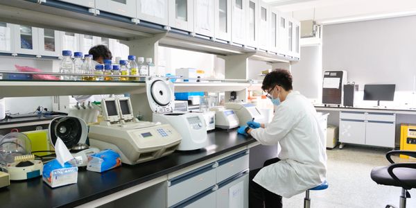 Scientist working in a modern laboratory with advanced equipment and safety gear.
