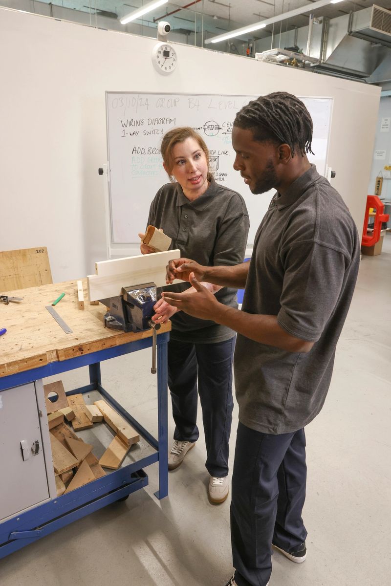 Woman assisting disabled man at workshop