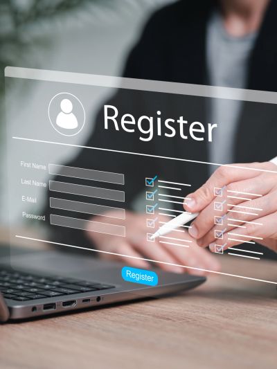Person filling out a digital registration form on a laptop.