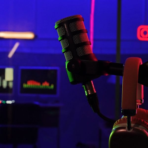 Close-up of a microphone and headphones in a dimly lit studio.