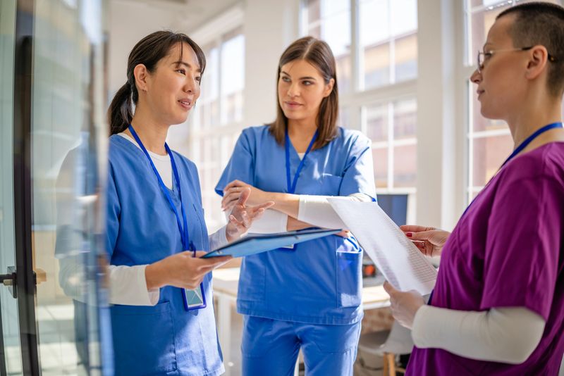 Healthcare professionals in a contemporary hospital environment engage in discussion and planning, collaborating on patient care strategies.
