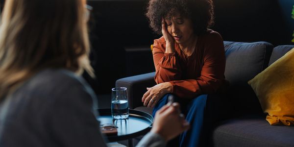 A woman expresses distress during a therapy session.