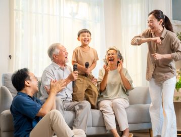 A joyful family enjoys singing karaoke together at home.