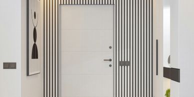 Modern white door with black vertical stripes in a minimalist hallway.