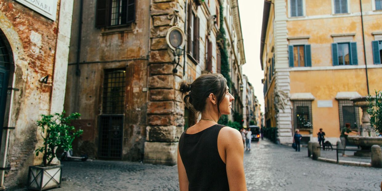 Woman walking through an Italy piazza.